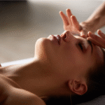 a woman relaxed while receiving a holistic spa treatment with healing hands.