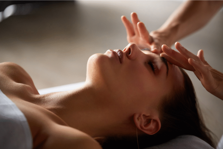 a woman relaxed while receiving a holistic spa treatment with healing hands.